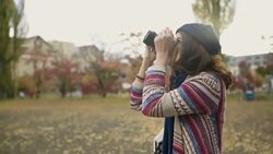 Woman taking pictures of Ginkgo tree with camera Stock Footage