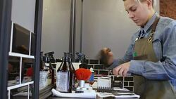 Barber cleaning electric razor with brush in shop Stock Footage