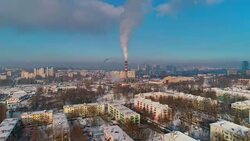 Bad ecology. The thermal power plant located in the center of the residential district, throws out smoke from the high pipe, polluting the atmosphere of the city. Aerial drone video with descending camera motion. Stock Footage