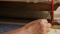 Traditional textile manufacture in craft village where old women work on wooden weaving loom machines and spin yarn creating silk or cotton fabric. Silk weaving in Thailand. Stock Footage