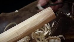 A wooden pole is roughly shaped with a tool, producing shavings. Stock Footage