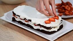 Assembling the cakes of chocolate biscuit. Preparation strawberry of biscuit cake. Baking a chocolate biscuit cake. Stock Footage