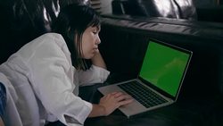 Woman is relaxation on sofa and using laptop with green screen Stock Footage