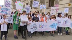 Children and their families with placards walking to Downing Street to protest over funding crisis in education for young people with special educational needs and disabilities News Clip