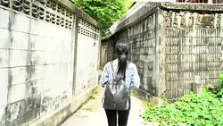 Beautiful young Asian woman talking on mobile phone and being stalked by man criminal on the street. Stock Footage