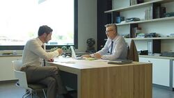 Businessmen discussing at desk in textile industry Stock Footage