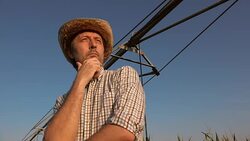 Serious concerned farmer in cornfield with irrigation system Stock Footage