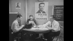 1960s: Campaign workers confer at table under poster reading Folks for Doakes Stock Footage