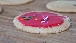 Decorating a cookie with candy sprinkles Stock Footage