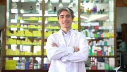 Smiling pharmacist with arms crossed in pharmacy Stock Footage