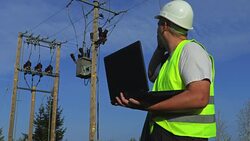 Electrician with portable computer talking on smart phone Stock Footage