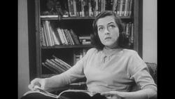 1950s: Wife sits in living room and reads magazine Stock Footage