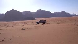 Wadi Rum - a local car crossing fast, in sandstone desert landscape Stock Footage
