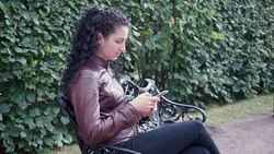 Brunette girl with curly hair with phone in hands Stock Footage
