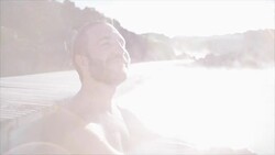 Geothermal spa. Man relaxing in hot spring pool in Iceland. Male enjoying bathing in a blue water lagoon Icelandic tourist attraction Stock Footage