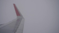 Airplane flight. Wing of an airplane flying above the clouds from window plane view Stock Footage