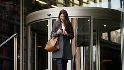 Businesswoman using mobile phone after work Stock Footage