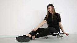 teenage girl in trendy hip hop clothes and cap posing against white wall with skateboard Stock Footage