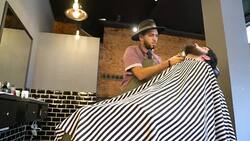 Hairdresser grooming customer's beard in salon Stock Footage