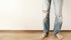 Dancing legs in torn jeans against the white wall Stock Footage