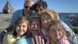 A big happy family takes a selfie or Uses Phone Video Call Camera on the seacoast. Stock Footage