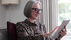 Mature adult female happily using a digital tablet Stock Footage