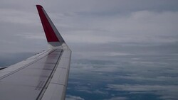 Airplane flight. Wing of an airplane flying above the clouds from window plane view Stock Footage