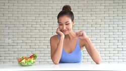 A beautiful young woman in joyful with a salad bowl on the side Stock Footage