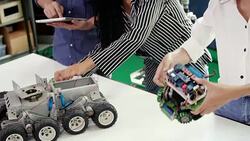 Teenage works on a fully functional programable Robot for robotics club project.Creative designer testing robotics prototype in workshop.Science concept Stock Footage