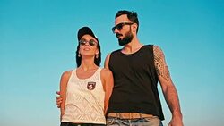 young woman and man enjoying the sunset in front of a blue sky Stock Footage