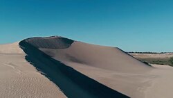 aerial footage a sand dune peak in a beautiful desert environment Stock Footage