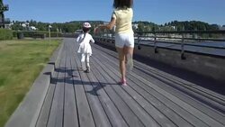 Two little girls playing on the wooden promenade. Outdoors. Stock Footage