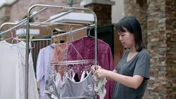 Woman hanging laundry on balcony Stock Footage