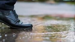 Man in black shoes stepping into the puddle in 4k slow motion 60fps Stock Footage