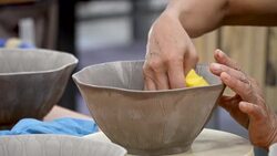 traditional pottery making, close up of potter's hands shaping a bowl on the spinning by clay Stock Footage