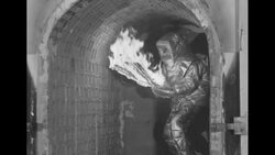 Demonstration of fireproof suit in furnace; wood, clothes, wicker burst into flames News Clip