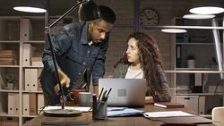 Diverse Coworkers Discussing Project on Laptop in Night Stock Footage