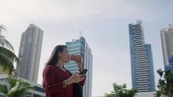 Asian Woman With Cell Phone Walking Near Office Buildings Stock Footage