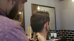 Barber trimming neckline of customer in salon Stock Footage