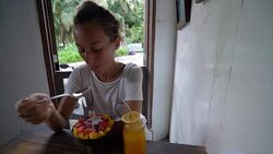 Girl having breakfast in healthy cafe, granola fruit power bowl and orange juice. Alternative lifestyles healthy people eating concept SLOW MOTION video Stock Footage
