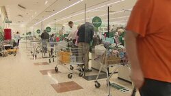Customer at checkouts in supermarket packing goods into bags News Clip