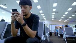 Young Asian man using mobile phone touchscreen and talking on phone. working on the phone, in the background of a Airport , planes, Concept: new business, travel, communication. Stock Footage