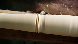 Decorative detail is added to a rotating peice of wood in a workshop, producing a turned, tapered chair leg. Stock Footage