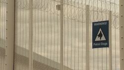 Signs on prison security fence News Clip