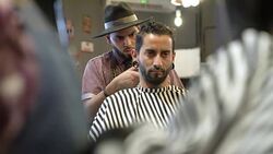 Trendy mid adult man getting his haircut by barber Stock Footage