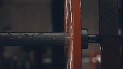 Strong male athlete adding weight plate to bar in gym Stock Footage