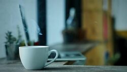 Coffee cup smoke on wood table and laptop background. Video Slow Motion Stock Footage