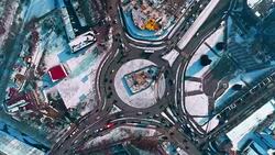 Directly above view on the roundabout with traffic in the winter city covered by snow Stock Footage
