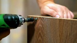 Fastening the panel with a screw using a screwdriver. Hand screwdriver in a horizontal position. furniture Stock Footage
