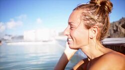 Geothermal spa. Woman relaxing in hot spring pool in Iceland. Girl enjoying bathing in a blue water lagoon Icelandic tourist attraction. SLOW MOTION Stock Footage